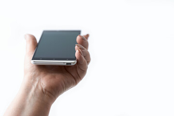 A woman's hand with a smartphone on a white background with an accent on the phone screen. Copy space. Selective focus.