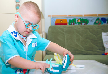 A boy with Down syndrome plays a role-playing game, a genetically ill disabled child in a doctor's...