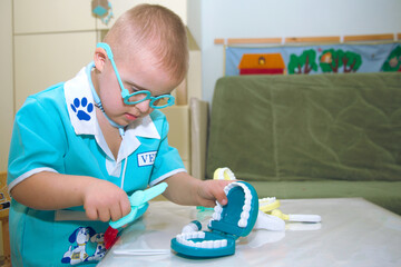 A boy with Down syndrome plays a role-playing game, a genetically ill disabled child in a doctor's...