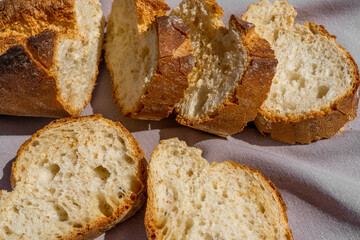 Delicious fresh baked baguette cut on a wooden cutting board