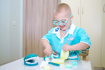 A boy with Down syndrome plays a role-playing game, a genetically ill disabled child in a doctor's...