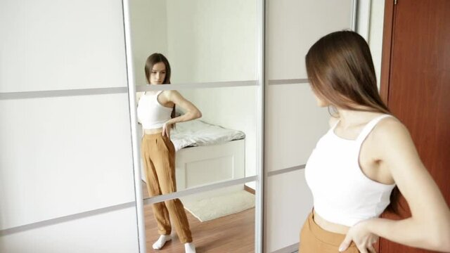 Teen anorexia, bulemia, skinny teen girl looks in the mirror and sees herself fat