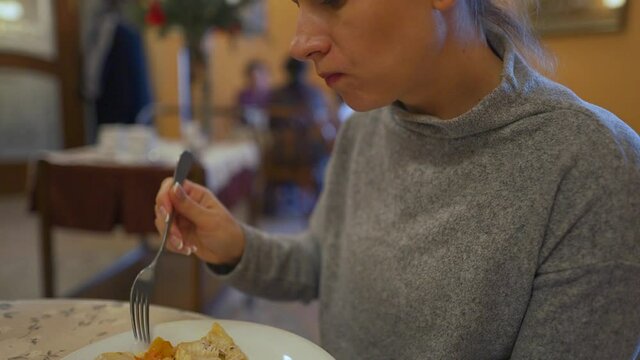 Woman is having lunch in a cafe. She eats fish and mashed potatoes