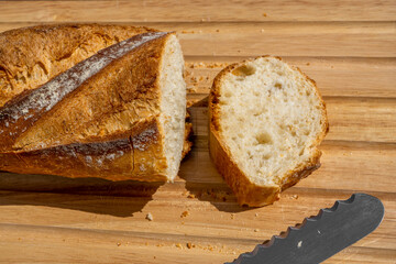 Delicious fresh baked baguette cut on a wooden cutting board