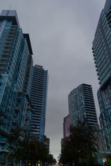 Fototapeta na wymiar City skyscrapers view from the road, on a rainy day, in Coal Harbour, Vancouver, BC