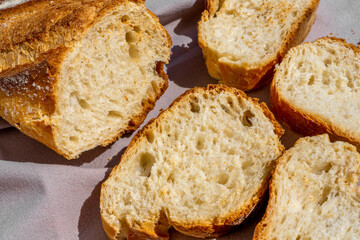 Delicious fresh baked baguette cut on a wooden cutting board