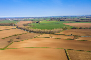 Fototapeta premium Aerial photo of a beautiful farmers field in the spring time in the town of Wetherby in Leeds in the UK taken in the Spring time