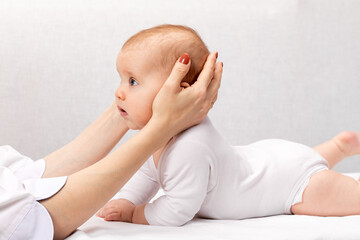 Little baby receiving osteopathic treatment of head and neck