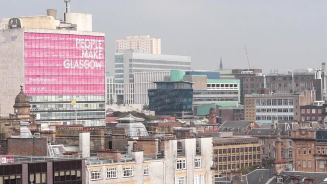 People make Glasgow slogan and view over district of city center, Scotland. Static shot