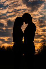 Silhouette of romantic couple in love, man and women in sunset sky. Romantic of relationships between couple love in the garden