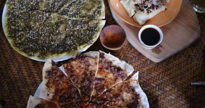 Middle eastern or arabic dishes and assorted meze: hummus, pita, Manakish Lahm Bi Ajeen - Flatbreads topped with minced meat and Fatayer stuffed pie. Halal food