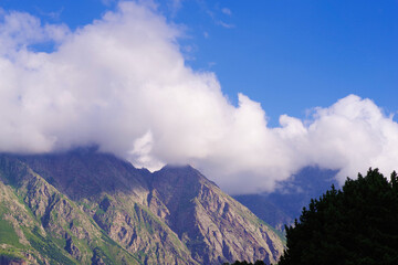 Snow-white clouds on the slopes of the mountains in the vicinity of Ushtulu
