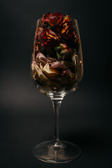 dry flower petals in a glass. black background. . High quality photo