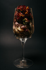 dry flower petals in a glass. black background. . High quality photo