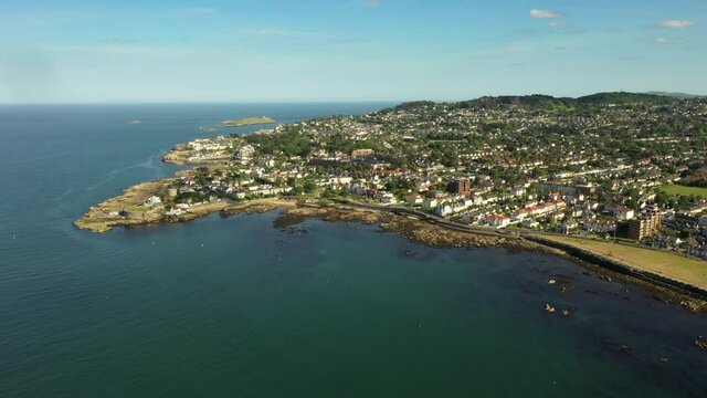 Sandycove Coastline, Dun Laoghaire Rathdown, Dublin, Ireland. Covid 19, June 2020. Drone pulls backward, with views of Forty Foot, Martello Tower, Bullock Harbour, Dalkey Island, and Killiney Hill.
