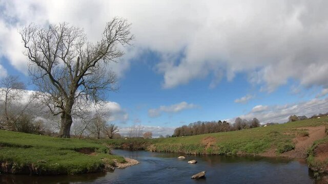 A sunny windy day on the river Arrow in Warwickshire, England as clouds roll over head.