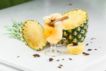 Mulled wine, grog and punch hot alcohol drinks on the table with seasonal decoration: pineapple,...
