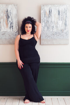 Beautiful plus size woman posing at camera, confident woman, wearing black suit