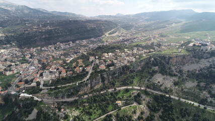 Fototapeta na wymiar Aerial view of the city. Middle east region. Beauty of Lebanon. Houses near the valley and mountains. Spring season. Best travel destinations. Vacation time. Mountain roads