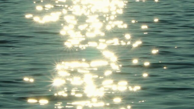 Sun reflecting on sparkling blue sea, ocean at sunset, sunrise