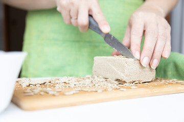 sunflower halva on a white table with seeds in women's hands