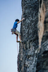 A climber on a steep rock. Rock climbing, extreme adrenaline sport climbing.