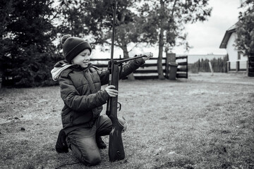 Young boy loading the rifle