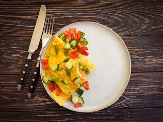 omelet with vegetables on a wooden background