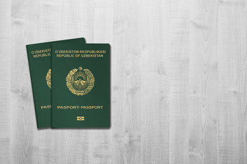Two Uzbekistan passports on a white wooden background, space for copies