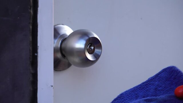 Footage 4K: Man using alcohol based sanitizer spray on door knob for disinfecting Coronavirus or Covid-19