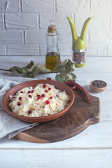 Sauerkraut with cranberries in a brown clay plate on a wooden background. Fermented vegetables. Super product for proper nutrition.