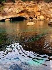 Paradise sea turquoise water lagoon with cave grotto of rocky Mediterranean coast.
