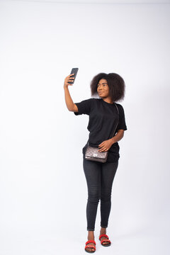 pretty young black woman taking a selfie with her phone