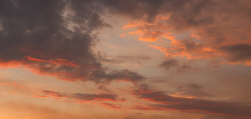 The sky at sunset before bad weather. Low red sunlight illuminates thunderclouds.