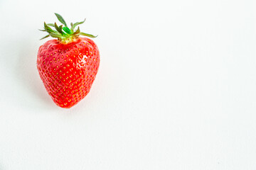 One bright strawberry on a white background, appetizing, beautiful, dietary. Place for text, copy space, flat lay