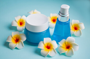 Obraz na płótnie Canvas moisturizing cream cosmetics in a jar for skin care with mango flowers