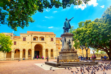 Columbus statue and Basilica Cathedral of Santa Maria la Menor in Santo Domingo Colonial zone. Parque Colon - obrazy, fototapety, plakaty