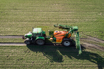 Luftbild - Traktor mit Pflanzenschutzspritze in einem jungen Getreidebestand im Einsatz, landwirtschaftliches Symbolfoto.