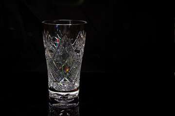 One empty crystal bowls symmetrically on a black background 