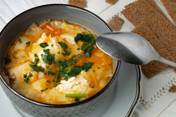 Bowl of a soup with chicken meatballs and a spoon