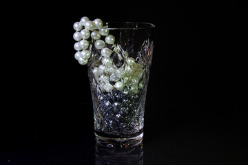 One empty crystal bowls symmetrically on a black background with white and black beads