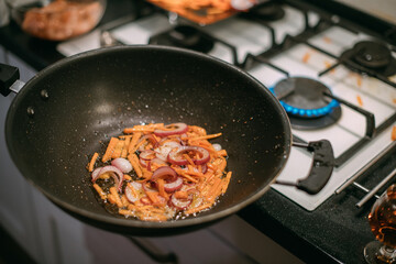 Frying pan with vegetables and meat close-up.