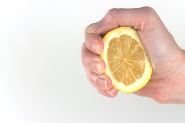 a woman 's hand squeezes a lemon on a white background