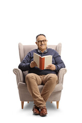 Smiling mature man sitting in an armchair and reading a book