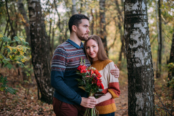 A romantic date, a walk in nature. Young couple of lovers together in the forest in early autumn.