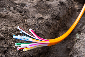 orange plastic cables for optical fiber, laid in an earth trench