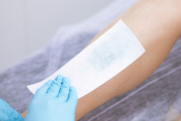 female legs hair removal with wax in beauty salon