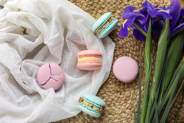 colorful delicious homemade traditional french macarons - elegant french dessert. Natural fruit and berry flavors, creamy stuffing and blue iris flowers on cloth for valentines mother day easter