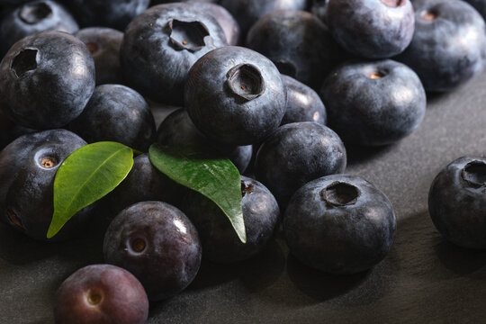 Fresh blueberries are scattered on a dark stone background. Products for a healthy diet. A source of vitamins. 