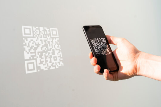 hand holding a smartphone and scan the qr code to make a payment